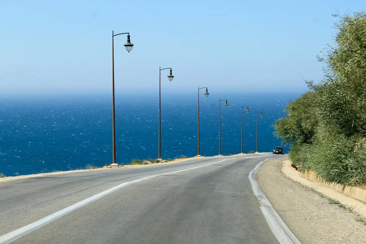The Adriatic coastal road curving along the cliffs above the sea in Montenegro, with the Bay of Kotor in the distance